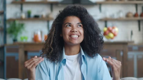 pov smiling african american young woman vlogger look at camera talk make live video conference call online chat, recording blog vlog sit on sofa at home, webcam view, video chat concept