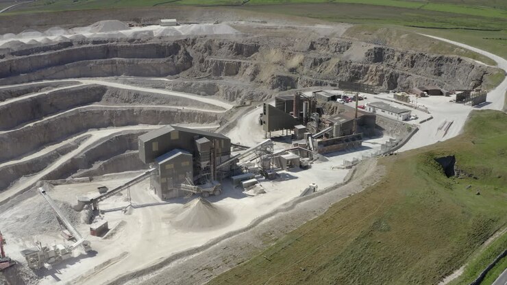 An aerial view of a working asphalt quarry building with the quarry cut in the background, Yorkshire, UK