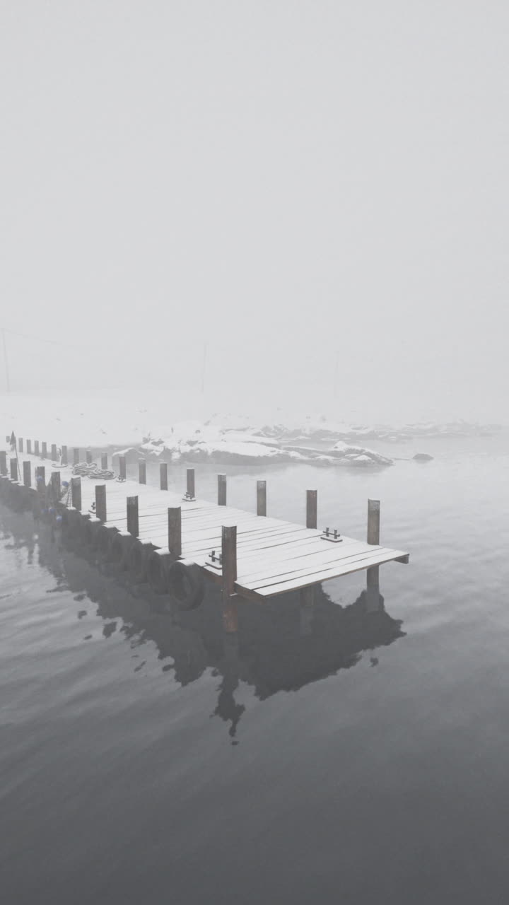 A Wooden Pier Extends Into a Foggy Lake
