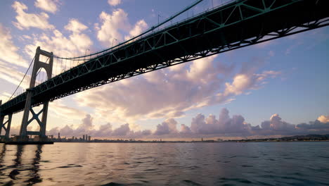 dramatic sunset or sunrise over a large suspension bridge and city skyline