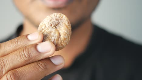 hand holding a dried fig