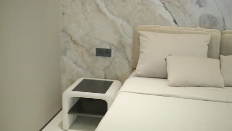 modern bedroom interior with bedside table and marble accent wall