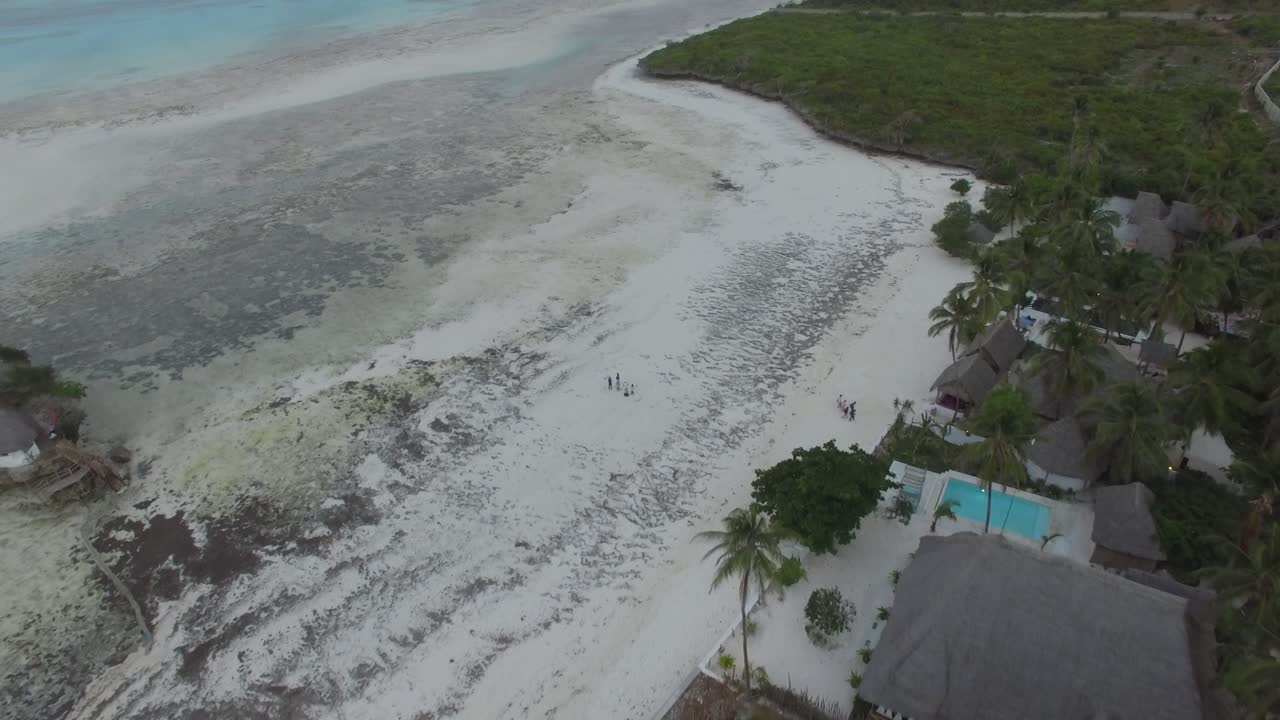 View from the sky of a tropical white sand beach and The Rock during low tide in Zanzibar, Tanzania