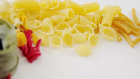 close-up of various qnd coloured pasta classified by category on white background