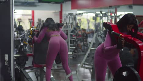 a woman is exercising at the gym, outfitted in sports attire