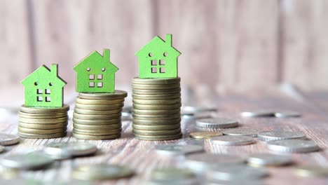 stack of coins and green color house on table, growth of property