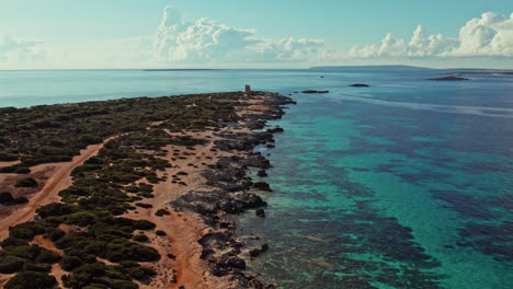 vista lejana de la torre de sus puertas en el parque natural de ses salinas, ibiza, españa