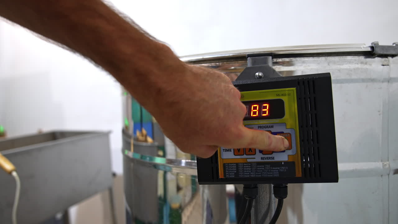Male hand switching on the button on the centrifuge apparatus. Man presses one more button to increase the speed of work of equipment. Close up.