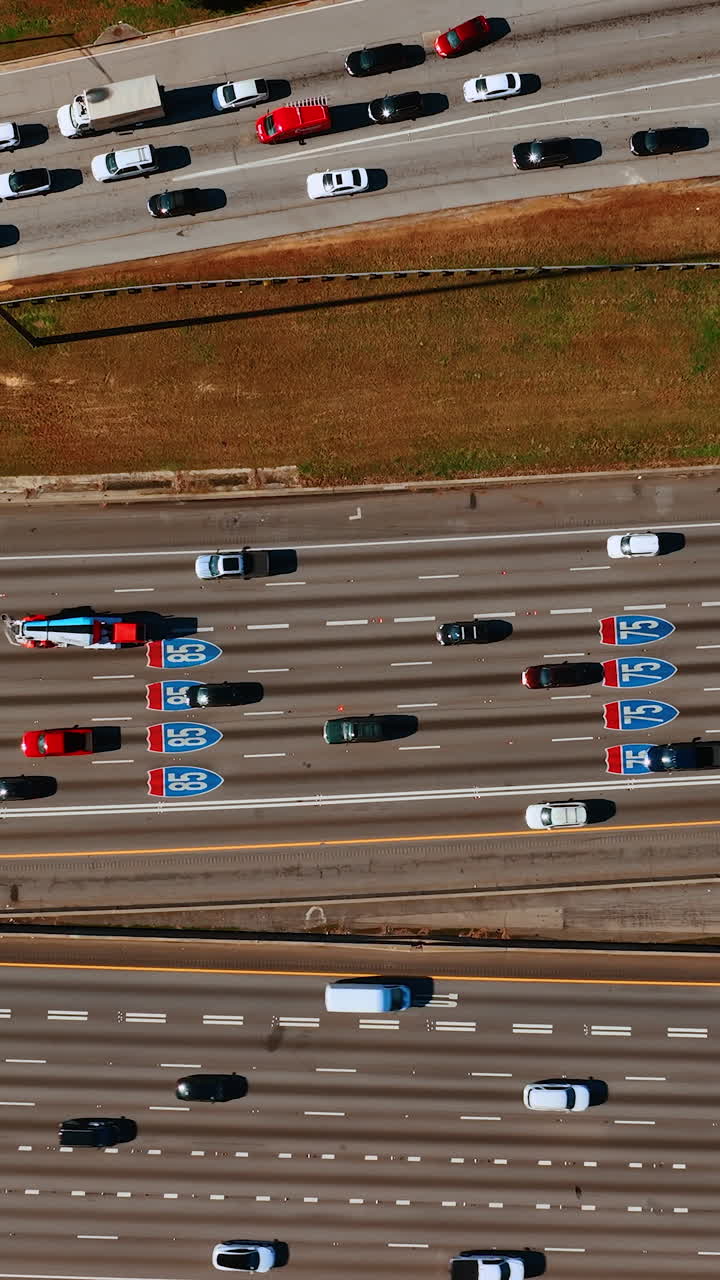 Private transport going by the multi-lane roads. Top view on the highway at daytime. Vertical video