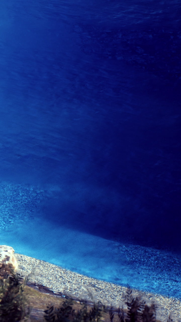 Exploring clear blue waters at a beach with rocky shore in daylight