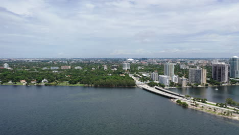 Vista-Aérea-Nublada-Durante-El-Día-Del-Centro-De-La-Ciudad-De-Miami,-Parque-Público-Y-Puente-Sobre-El-Océano-Cinemático-4k