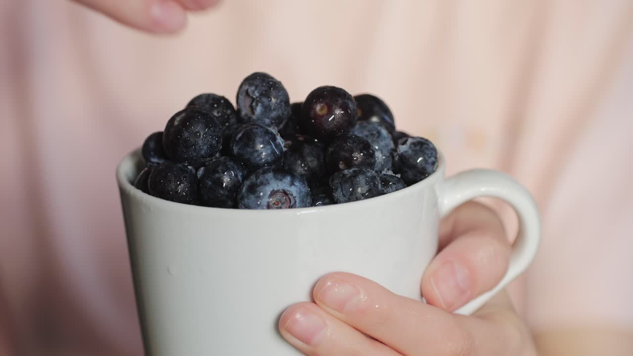 Woman holding a cup of blueberries