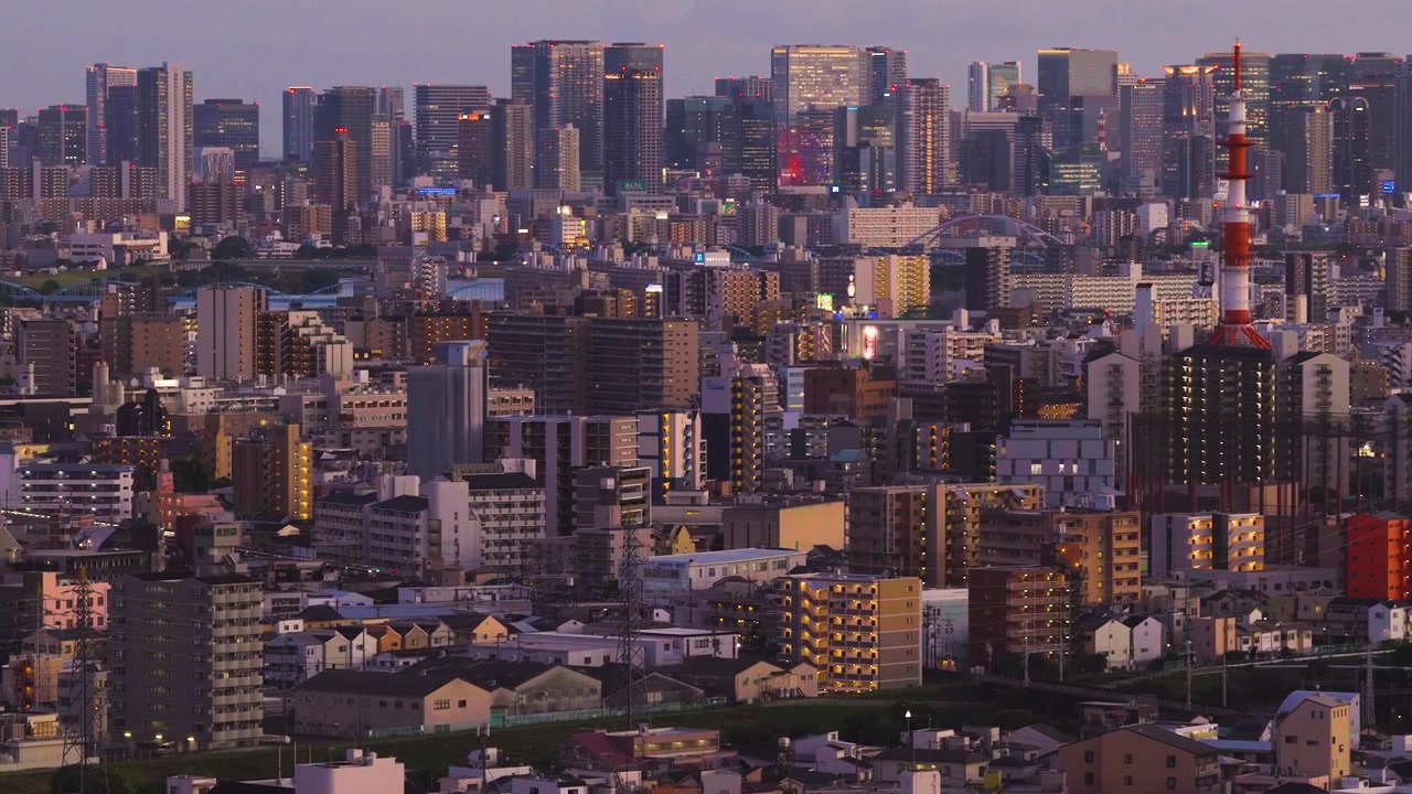 夕暮れの大阪市街のスカイライン。日本の関西の中心都市がチルトアップで現れる。