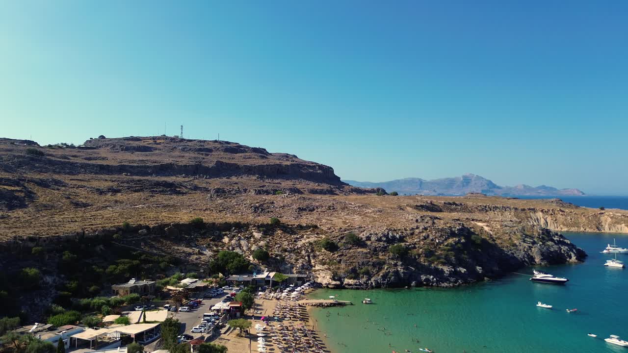 playa y pueblo de lindos en rodas, grecia con la acrópolis de lindos, casas y mar mediterráneo durante el día filmado con el dron