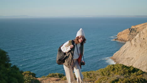 hiker traveling ocean mountain on spring vacation. smiling girl taking picture