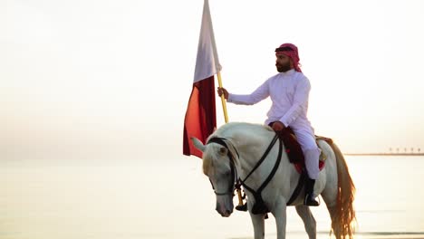 a knight on a horse holding qatar flag in slow motion