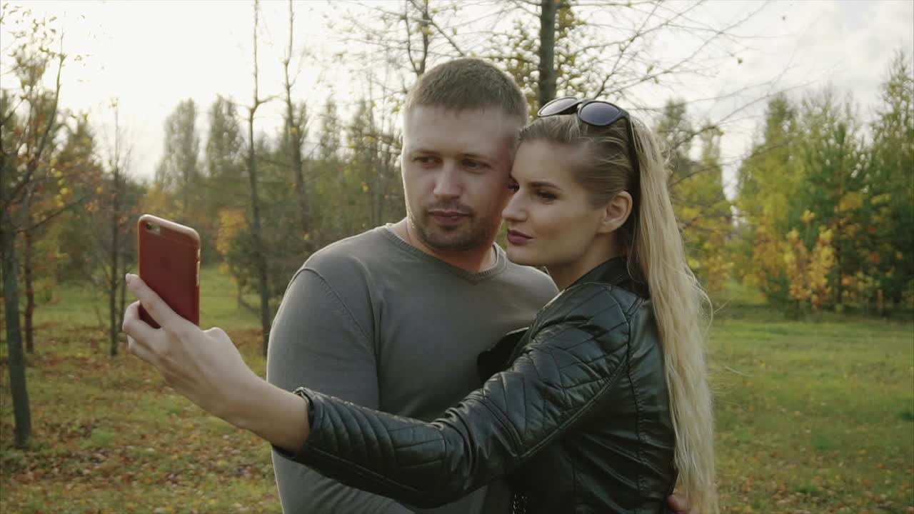 Coppia che si fa un selfie in un parco autunnale