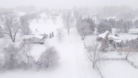 small american town covered in deep layer of snow during blizzard, aerial view