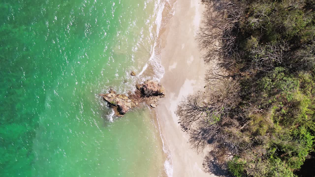 toma aérea de arriba hacia abajo de una roca en una playa en la isla tortuga, costa rica