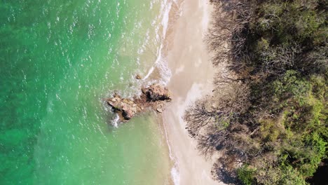 Toma-Aérea-De-Arriba-Hacia-Abajo-De-Una-Roca-En-Una-Playa-En-La-Isla-Tortuga,-Costa-Rica