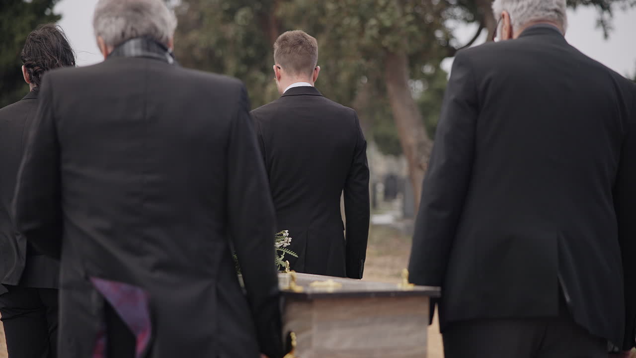 Uomini, bara e portatori di bara che camminano al funerale
