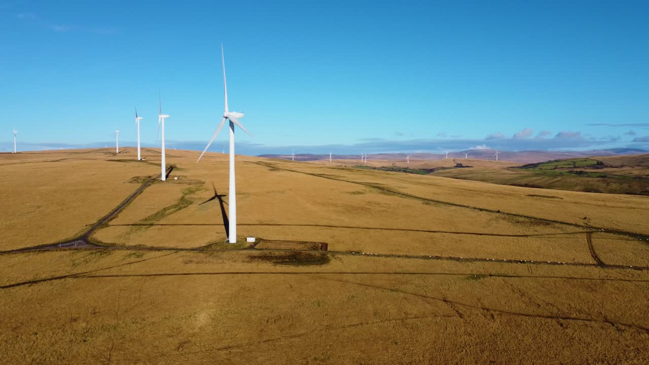 Open Landscape with Collection of Wind Turbines Scattered Over Grassy Moorland. Rotors Spinning Providing Renewable Power. Sustainable Energy for Net Zero