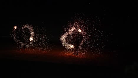 dancers create fiery circles on the beach