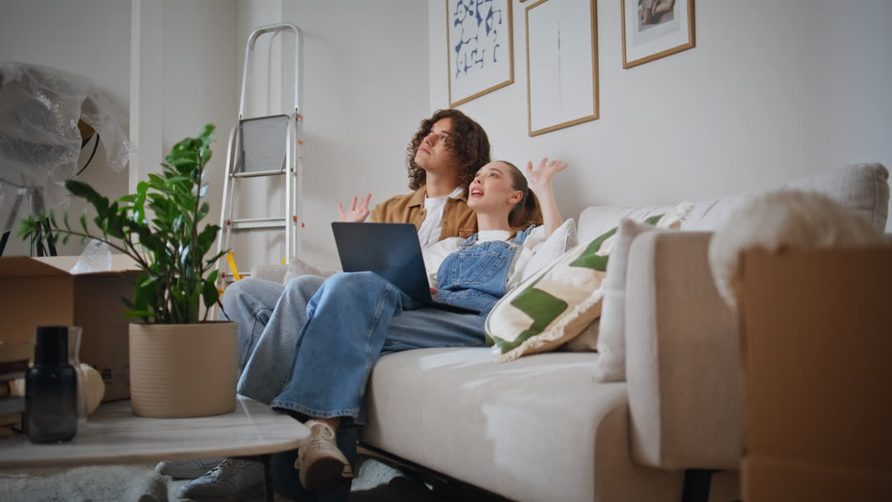 Family pair relaxing couch holding laptop. Relaxed woman on sofa talking partner