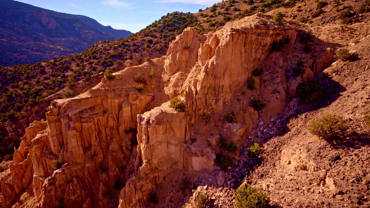 Ripresa con drone che rivela un terreno roccioso a strapiombo di colore rosso e dalla superficie irregolare