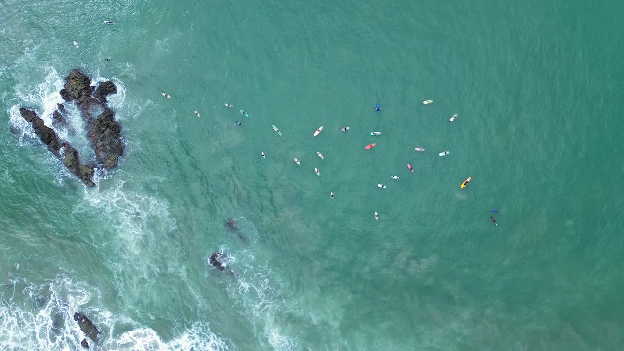 Aerial View of Many People Surfing in the Ocean