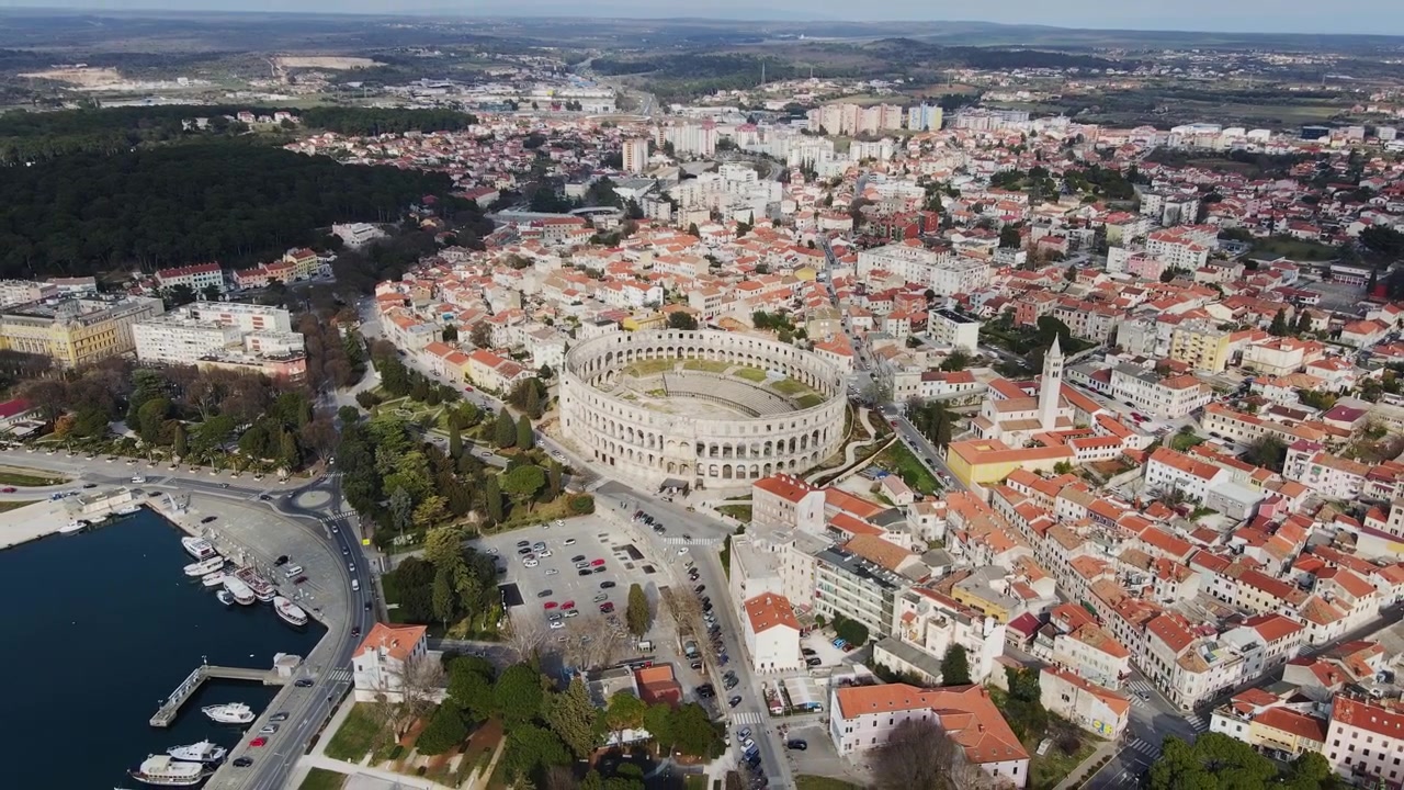 4K letecký pohled na římský amfiteátr v Pule, obklopený historickými červenými střechami.