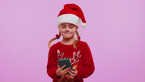 Girl-in-Christmas-sweater,-hat-using-mobile-phone-typing-new-post-on-web,-shopping-online,-browsing