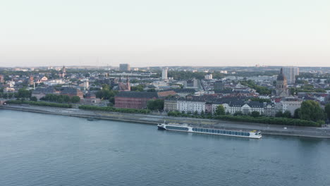 aerial circling drone view of mainz ship rhine river, castle, dom, theodor heuss bridge and cityscape at sunset germany 4k