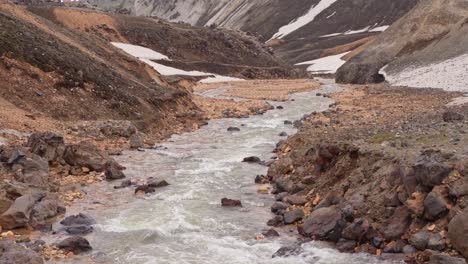 Fixed-wide-view-of-the-clear-water-river-descending-from-Brennisteinsalda-in-the-Landmannalaugar-region