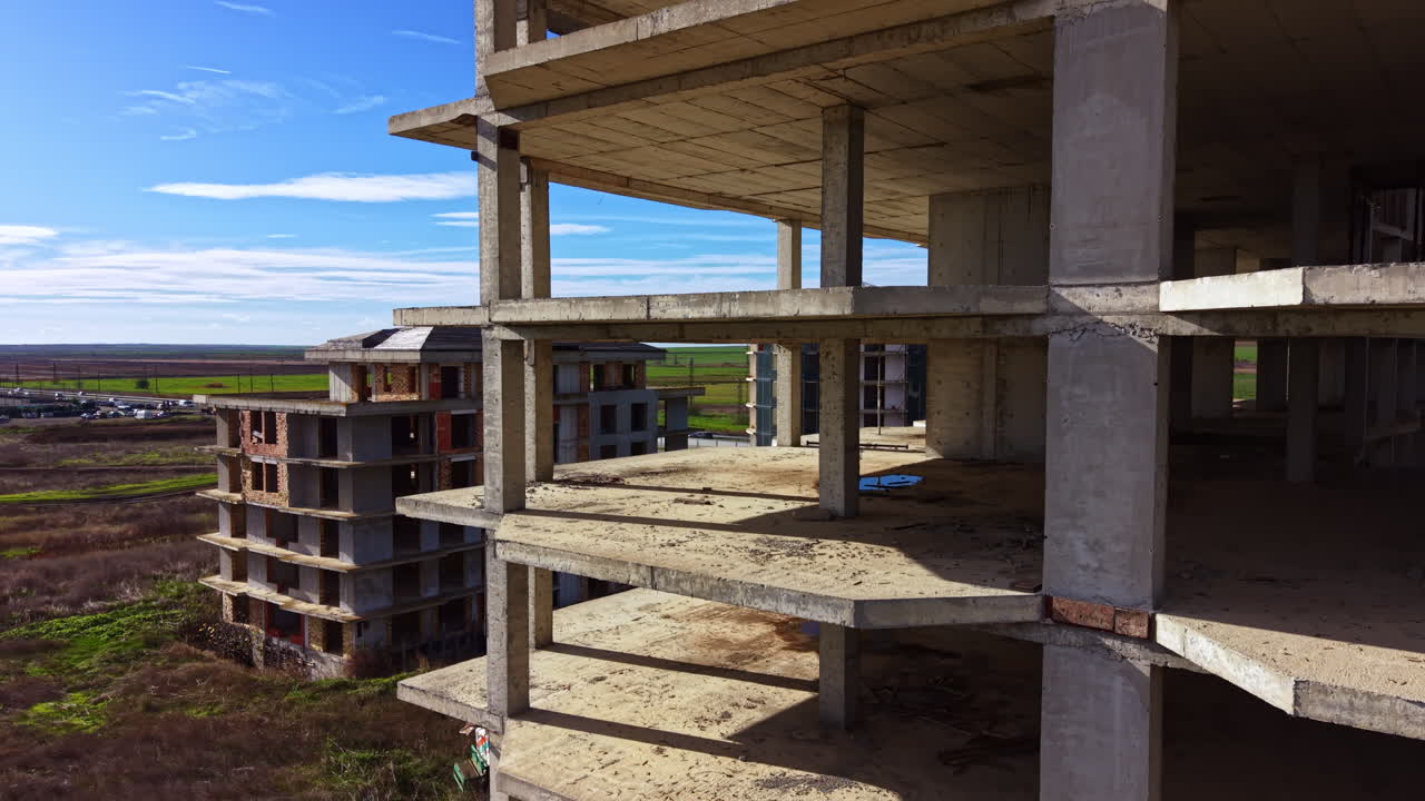 Abandoned concrete structures under a vast blue sky invite stories from a forgotten time in a quiet landscape