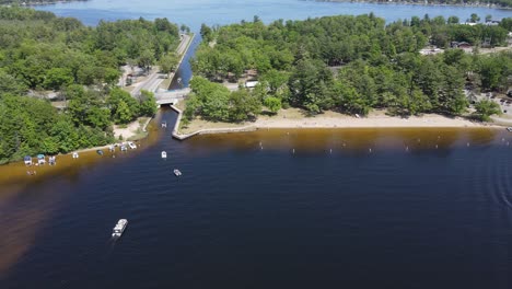 Canal-connecting-two-lakes-for-boats-in-Michigan,-aerial-descend-view