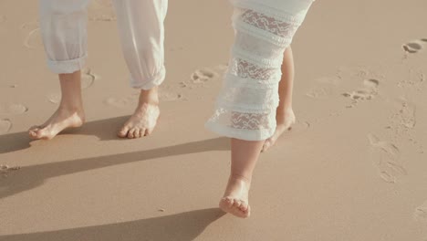 two barefoot figures walking gently along golden beach sand