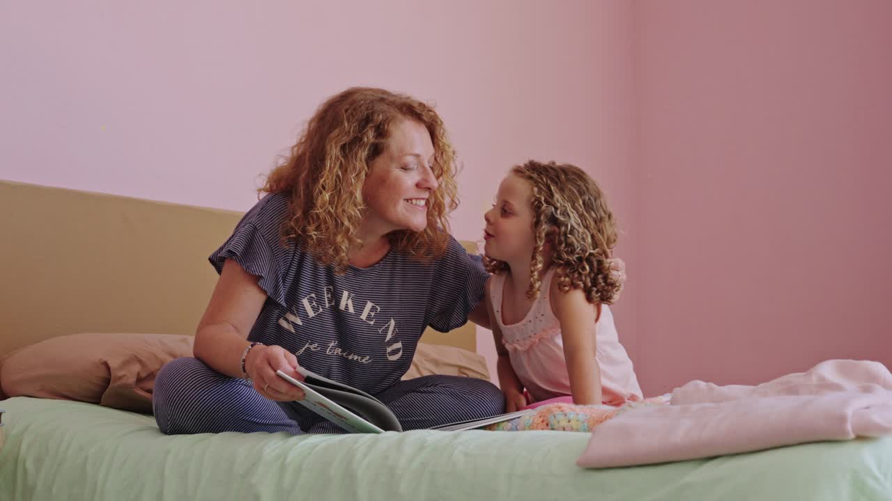 Mother and Daughter Reading Together on Bed