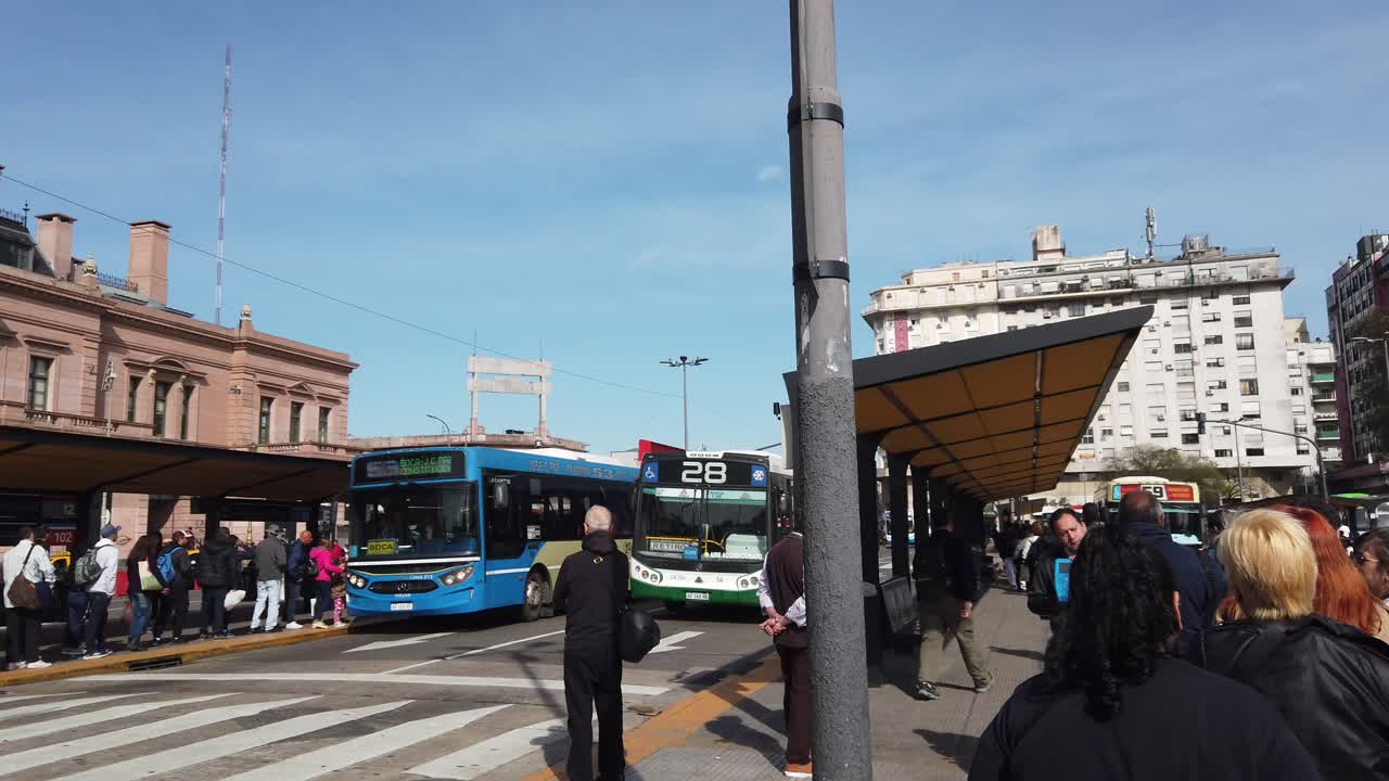 Pedestrians waiting at bus stop of Constitucion square plaza, buenos aires city panoramic morning daylight