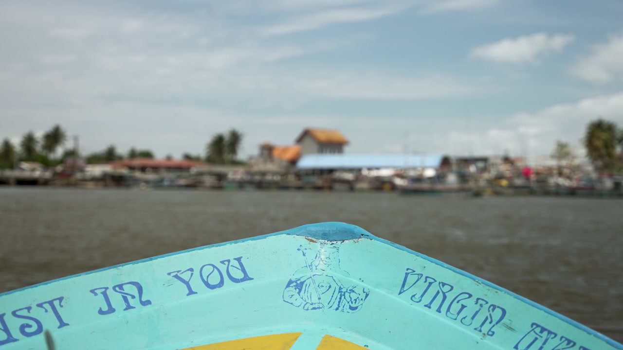 Prua colorata di una barca che naviga sulla laguna di Negombo con un mercato del pesce sullo sfondo in Sri Lanka