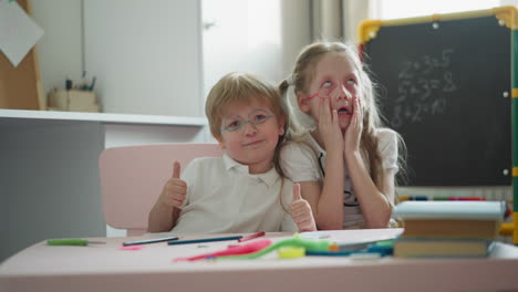 Little-boy-shows-thumbs-up-and-girl-grimaces-funnily