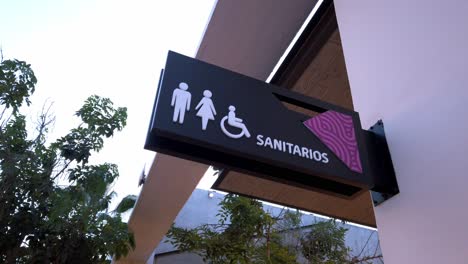 fixed shot of sanitary restroom sign for men, women and disabled access on commercial building facade