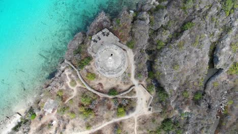 Historischer-Steinturm-Am-Tugboat-Beach-In-Curaçao-Mit-Klarem-Wasser-Und-Wanderwegen,-Luftaufnahme