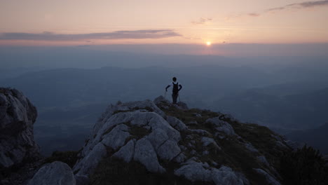 hiker standing at the edhe of a mountain ridge to admire the early morning vive and the sunrise