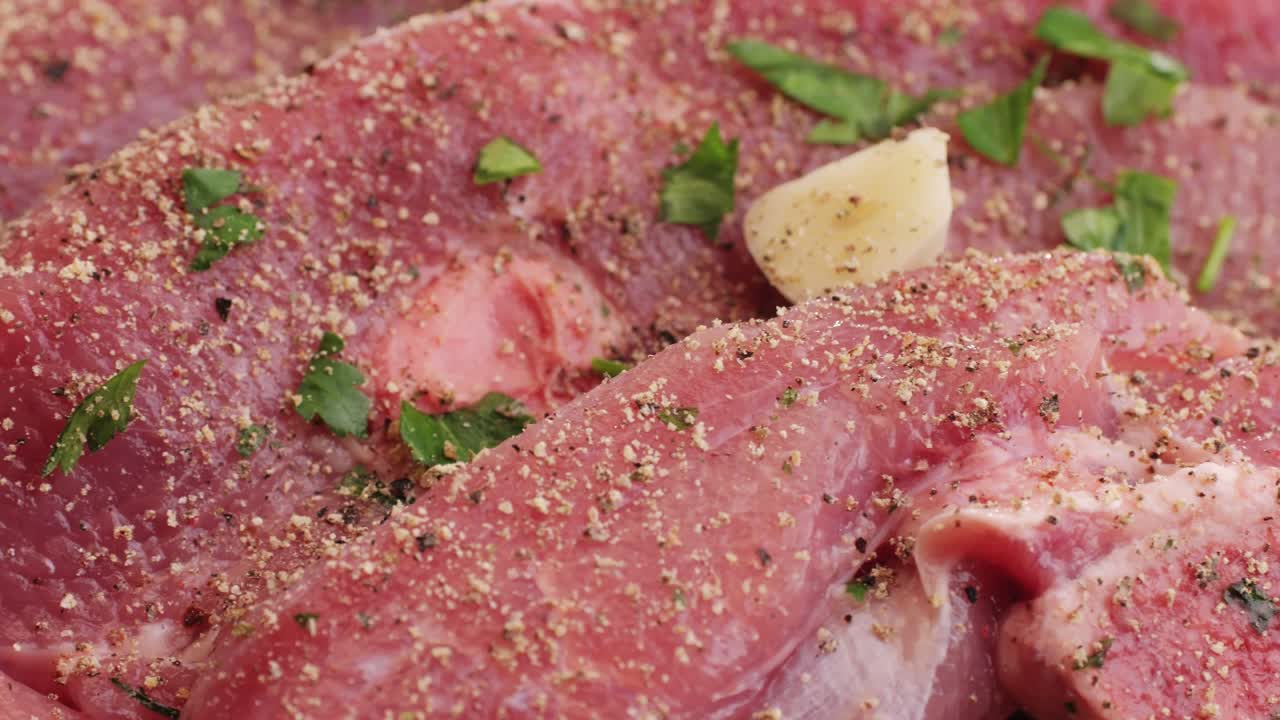 Raw slice beef meat in spices: paprika, salt, pepper, turmeric on plate close-up. Preparing raw food for cooking. Grill and Fry beef, pork, chicken, duck, turkey kebab with vegetables.