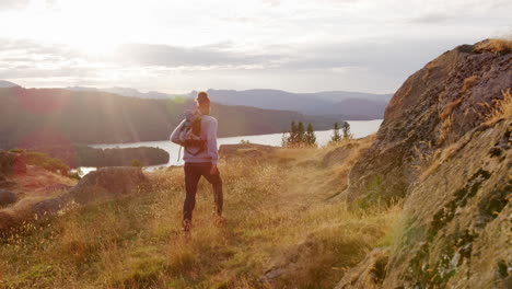 A-young-adult-mixed-race-man-stops-to-admire-the-view-during-a-mountain-hike,-handheld