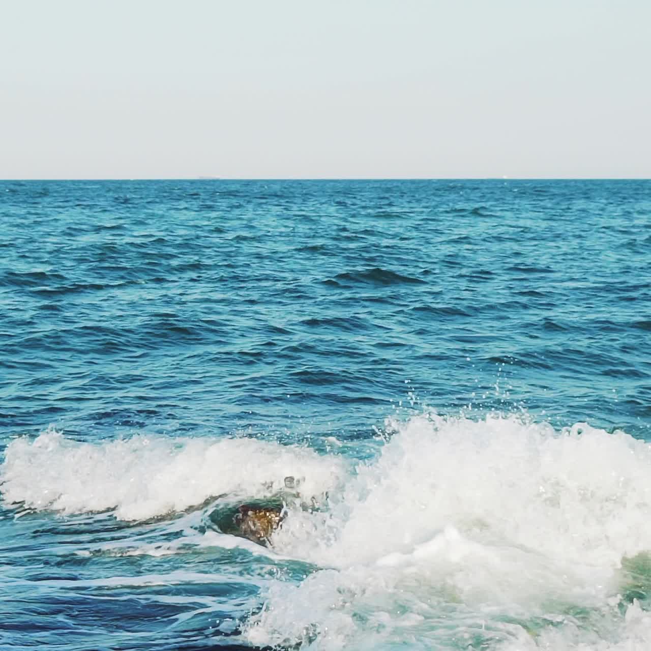 Sea waves are colliding with underwater reefs. Sea spray. Close-up. Water drops. Slow motion