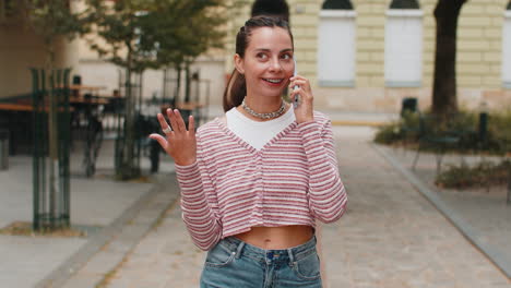 mujer feliz en una conversación agradable en el teléfono inteligente disfrutando de hablar chatear con amigos en la calle de la ciudad