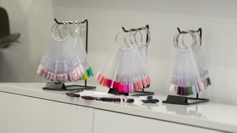 in manicure salon there is a set of artificial nails with different options of nail varnish colors