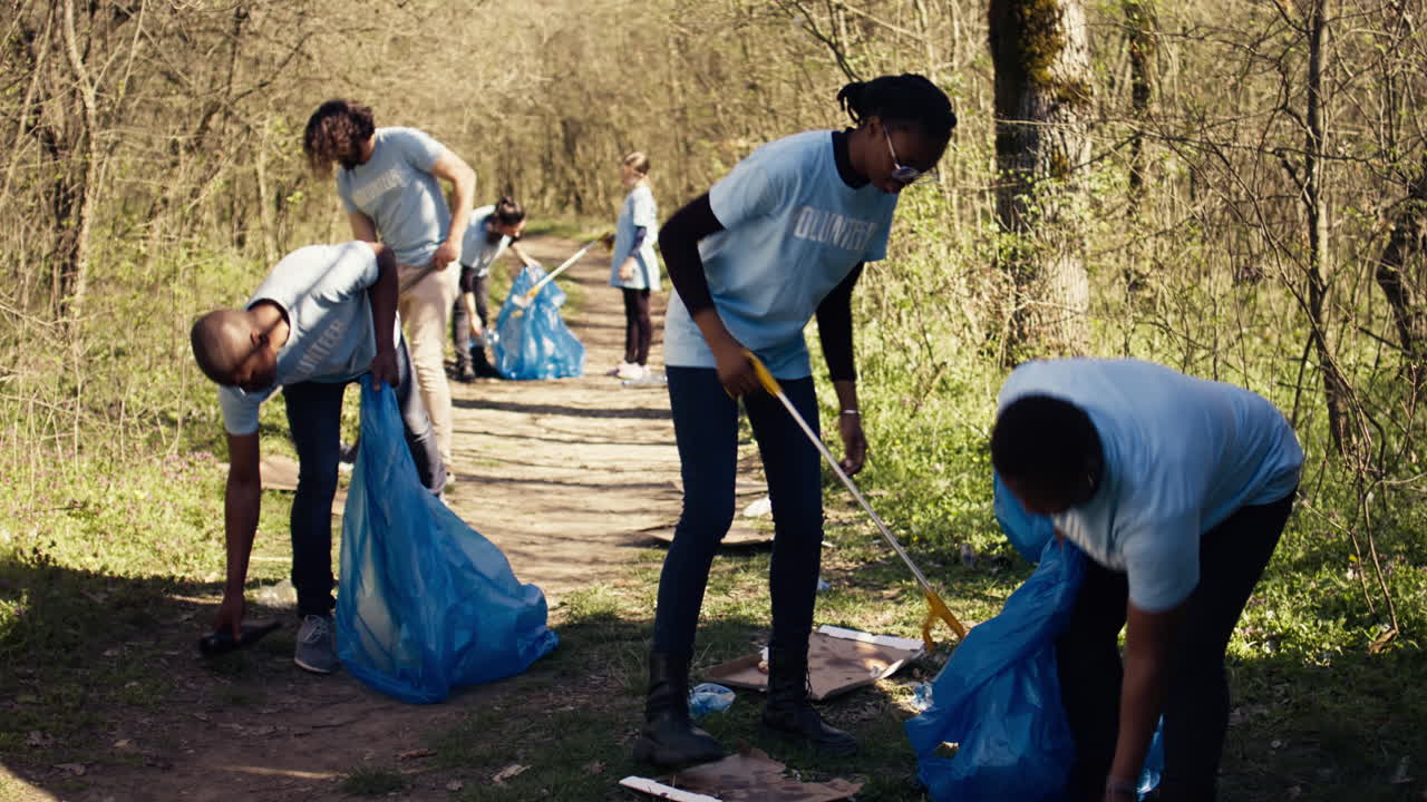 Environmental activists collecting rubbish and plastic waste in garbage bag